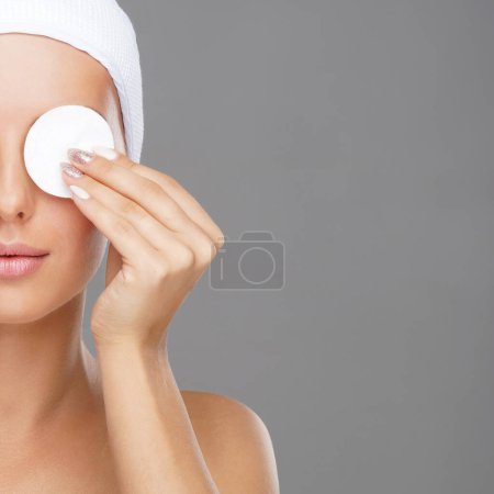 Téléchargez les photos : Une jeune femme se nettoie le visage avec des tampons de coton. Fille enlever les cosmétiques avec des disques hygiéniques. Concept cosmétologie
. - en image libre de droit