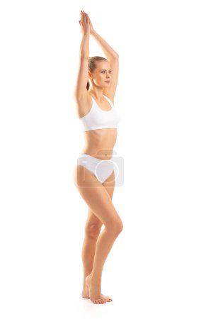 Photo for Young, fit and beautiful blond woman in white swimsuit isolated on grey background. The concept of healthcare, diet, sport and fitness. - Royalty Free Image