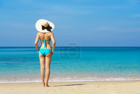 Photo for A beautiful woman in a swimsuit posing on a Thai beach at summer. Holiday, vacation, traveling and resort concept. - Royalty Free Image