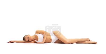 Photo for Young, fit and beautiful blond woman in white swimsuit isolated on grey background. The concept of healthcare, diet, sport and fitness. - Royalty Free Image