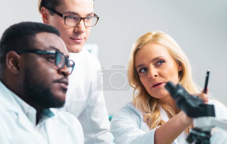 Photo for Team of professional scientists working on a vaccine in a modern scientific research laboratory. Genetic engineer workplace. Laboratory tools: microscope, test tubes, equipment. Future technology - Royalty Free Image