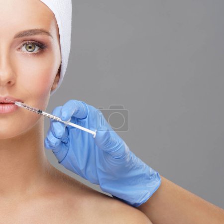 Foto de Doctor inyectando en una cara hermosa de una mujer joven. Cirugía plástica, lifting de piel y medicina estética. - Imagen libre de derechos