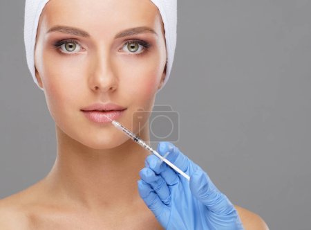 Photo for Doctor injecting in a beautiful face of a young woman. Plastic surgery, skin lifting and aesthetic medicine concept. - Royalty Free Image