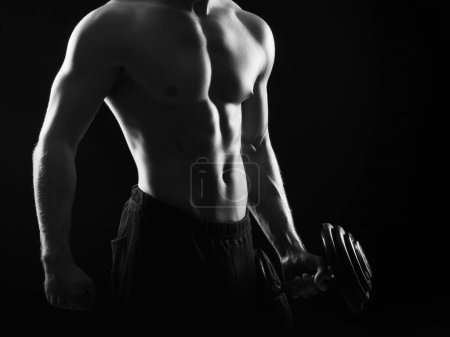 Téléchargez les photos : Homme de bodybuilder fort, en forme et sportif sur fond noir. Concept sport et fitness - en image libre de droit