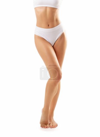 Foto de Joven y hermosa chica delgada en traje de baño blanco posando sobre fondo blanco. El concepto de salud, dieta, deporte y fitness. - Imagen libre de derechos