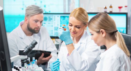 Equipo de científicos profesionales que trabajan en una vacuna en un moderno laboratorio de investigación científica. Trabajo de ingeniero genético. Herramientas de laboratorio: microscopio, tubos de ensayo, equipo. Tecnología futura