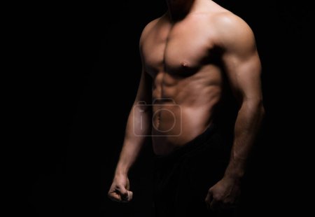 Foto de Hombre fuerte, en forma y deportivo culturista sobre fondo negro. Concepto de deporte y fitness - Imagen libre de derechos