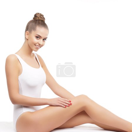 Téléchargez les photos : Jeune, en forme et belle femme brune en maillot de bain blanc posant sur fond blanc. Santé, alimentation, sport et fitness concept. - en image libre de droit