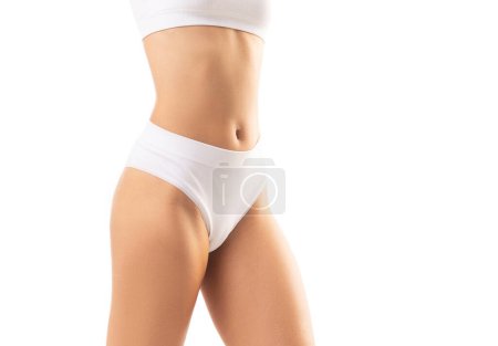 Téléchargez les photos : Jeune, en forme et belle femme en maillot de bain blanc sur fond blanc. Santé, alimentation, sport et fitness concept. - en image libre de droit