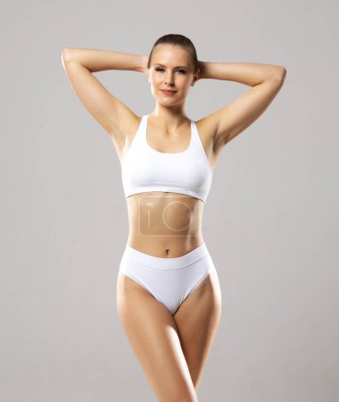 Foto de Mujer joven, en forma y hermosa en traje de baño blanco sobre fondo blanco. Salud, dieta, deporte y fitness. - Imagen libre de derechos