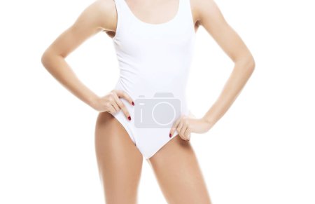 Téléchargez les photos : Jeune, en forme et belle femme en maillot de bain blanc sur fond blanc. Le concept de santé, d'alimentation, de sport et de fitness. - en image libre de droit