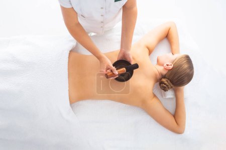 Jeune femme se faisant masser traitement sur fond blanc. Concept Spa, soins de santé et loisirs.