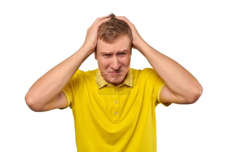 Téléchargez les photos : Upset man in yellow T-shirt clutched at his head, forgetful man with headache isolated on white background. Young guy worried and frustrated, grabbed his head, sharp severe headache - en image libre de droit