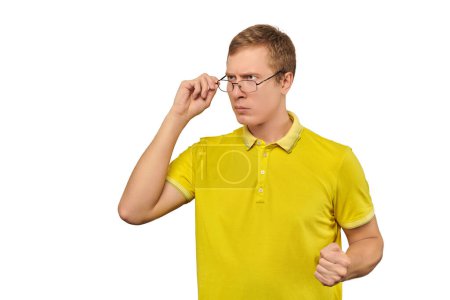 Téléchargez les photos : Unhappy geek in glasses and yellow T-shirt ready to fight with fists isolated on white background. Funny man ready to fight back offender, nerd guy with clenched fist, bullying defense - en image libre de droit