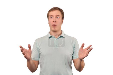Foto de Confused young guy shrugged shoulders, guy in mint casual T-shirt spread arms, isolated on white background. Puzzled young man spread his hands, bewildered don't know gesture - Imagen libre de derechos