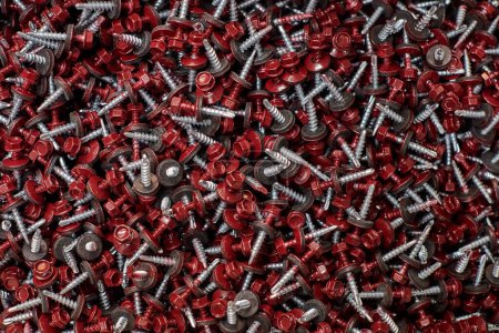 Téléchargez les photos : Bunch of galvanized self-drilling screws with washer and red hexagonal head, hardware background. Group of hex head silver screws for metalworking and construction work with fasteners - en image libre de droit