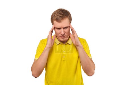 Foto de Stressed young man in yellow T-shirt with migraine headache isolated on white background. Tired overworked guy with pain in head, symptom of raised intracranial pressure - Imagen libre de derechos