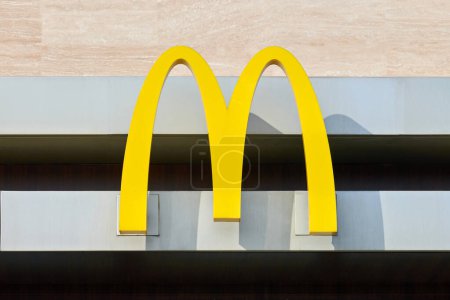 Photo for Rostov on Don, Russia - 02.21.2022 - McDonalds logo on fast food restaurant branch, yellow macdonald logo of popular fast food company. Mac donald brand logotype above entrance to cafe - Royalty Free Image