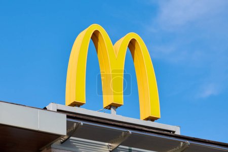 Photo for Rostov on Don, Russia - 02.21.2022 - McDonalds logo on roof of fast food restaurant branch, yellow macdonald logo of popular fast food company. Mac donald brand logotype above entrance to cafe - Royalty Free Image