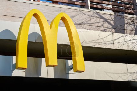 Photo for Rostov on Don, Russia - 02.21.2022 - McDonalds logo on fast food restaurant branch, yellow macdonald logo of popular fast food company. Mac donald brand logotype above entrance to cafe - Royalty Free Image