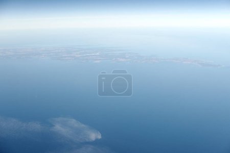 Photo for Aerial view from airplane window to Gotland island in Baltic sea, beautiful largest island in Sweden. Beautiful hazed sky aerial view to blue baltic sea, aerial seascape background - Royalty Free Image
