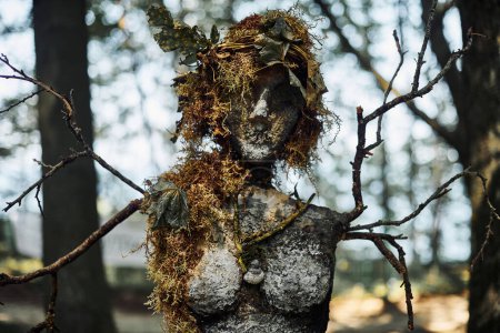 Photo for Creepy witch statue art object on forest background made of mud plaster and dry grass, mystical mysterious gloomy statue of woman child of nature. Female scary recycling sculpture in woods - Royalty Free Image