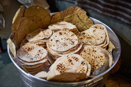 Téléchargez les photos : Lot de chapati pains plats ronds dans le seau pour langar dans le temple gurudwara sikh, de nombreux pains plats roti savoureux fabriqués à partir de farine de blé entier moulue en pierre, pain traditionnel indien sans levain pas cher - en image libre de droit