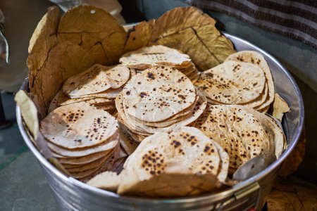 Téléchargez les photos : Lot de chapati pains plats ronds dans le seau pour langar dans le temple gurudwara sikh, de nombreux pains plats roti savoureux fabriqués à partir de farine de blé entier moulue en pierre, pain traditionnel indien sans levain pas cher - en image libre de droit