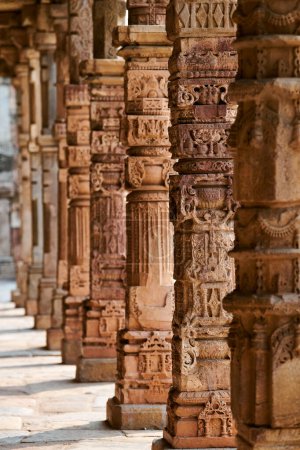 Photo for Stone columns with decorative bas relief of Qutb complex in South Delhi, India, close up pillars in ancient ruins of mosque landmark, popular touristic spot in New Delhi, ancient indian architecture - Royalty Free Image