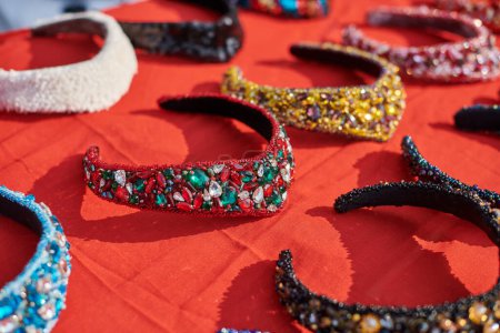 Photo for Different traditional russian headwear exhibition, decorative headbands decorated colorful jewelry on red table, russian headdresses beaded sparkling jewelry, beautiful russian headband - Royalty Free Image