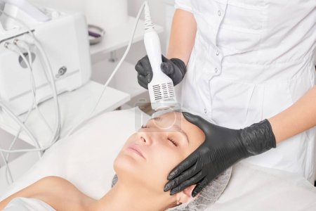 Beautician makes cryotherapy for rejuvenation woman face, anti aging cosmetic procedure with in beauty spa salon. Cosmetologist makes cryo therapy lifting with for skin rejuvenation and smoothing