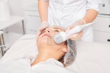 Téléchargez les photos : Esthéticienne fait cryothérapie pour rajeunissement visage de la femme, procédure cosmétique anti-âge avec dans le salon de beauté spa. Cosmetologue fait cryothérapie levage avec pour rajeunissement de la peau et lissage - en image libre de droit