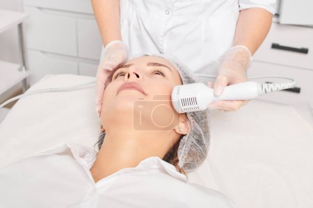 Photo for Cosmetologist makes cryotherapy for rejuvenation woman face, anti aging cosmetic procedure with in beauty spa salon. Beautician makes cryo therapy lifting with for skin rejuvenation and smoothing - Royalty Free Image