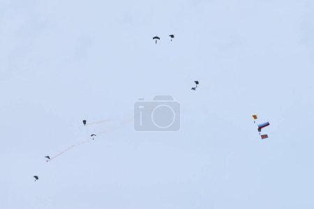 Fallschirmjäger der Luftstreitkräfte, die die russische Flagge und Flaggen militärischer Einheiten in die Höhe halten, Militärübung zum Tag der Luftstreitkräfte mit Formationslandung, Abstieg der Luftstreitkräfte