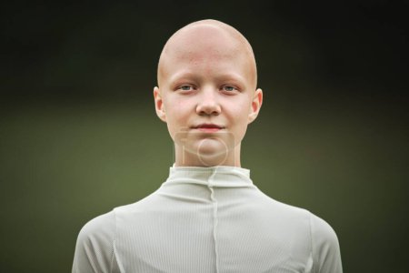 Photo for Portrait of young hairless girl with alopecia in white cloth on green park background, bald pretty teenage girl symbolizing acceptance individuality and challenging conventional standards of beauty - Royalty Free Image