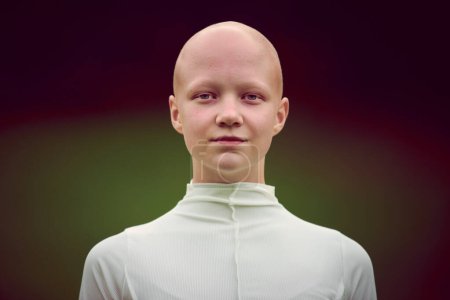 Photo for Portrait of young hairless girl with alopecia in white cloth on green park background, bald pretty teenage girl symbolizing acceptance individuality and challenging conventional standards of beauty - Royalty Free Image