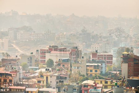 Blick auf Kathmandu Hauptstadt Nepals vom Berg durch urbanen Dunst mit vielen niedrigen Gebäuden, Stadtbild schafft eine ätherische Atmosphäre in der Bergluft, Luftverschmutzung in Kathmandu