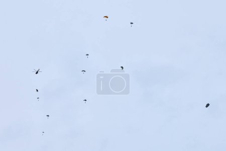 Fuerzas aerotransportadas paracaidistas ondeando la bandera de Rusia y banderas de unidades militares, ejercicio militar para la celebración del Día de las Fuerzas Aerotransportadas con el aterrizaje de formación, la división aerotransportada del ejército desciende