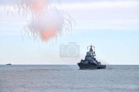 Photo for Russian warship fired decoy flares for self defense, sailing at sea military ship used anti missile protection throw heat seeking missiles off course, Russian sea power deployment demonstration - Royalty Free Image