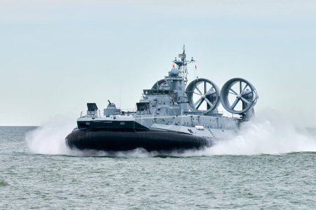Photo for Hovercraft warship armed with armament sails into sea toward military target to attack and destroy enemy, military hovercraft ship performing strategic maneuver, Russian sea power deployment - Royalty Free Image