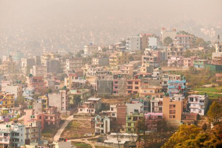 Vista de Katmandú capital de Nepal desde la montaña a través de la neblina urbana con muchos edificios de poca altura, paisaje urbano que crea una atmósfera etérea en el aire de montaña, contaminación del aire de Katmandú