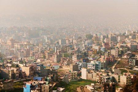 Blick auf Kathmandu Hauptstadt Nepals vom Berg durch urbanen Dunst mit vielen niedrigen Gebäuden, Stadtbild schafft eine ätherische Atmosphäre in der Bergluft, Luftverschmutzung in Kathmandu