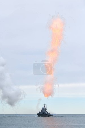 Photo for Russian warship fired decoy flares for self defense, sailing at sea military ship used anti missile protection throw heat seeking missiles off course, Russian sea power deployment demonstration - Royalty Free Image