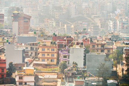 Téléchargez les photos : Vue de Katmandou capitale du Népal de la montagne à la brume urbaine avec beaucoup de bâtiments de faible hauteur, paysage urbain créant une atmosphère éthérique dans l'air de montagne, pollution atmosphérique de Katmandou - en image libre de droit