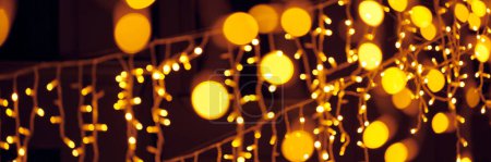 Verschwommenes Flackern der Lichter hängender Girlanden für Silvester Straßendekorationen in der Nacht, frohe Weihnachten und fröhliche Neujahrsstimmung mit defokussierten funkelnden Lichtern Bokeh