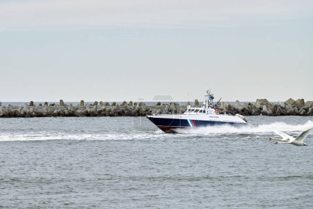 Photo for Coast guard boat sails along seaside for safeguarding coastal boundaries and maritime interests symbolizing maritime protection, coast guard ship patrolling waters protects state border - Royalty Free Image