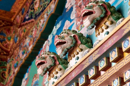Schneelöwen mit türkisfarbenen Mähnen Basreliefs an der Wand über dem Eingang zum buddhistischen Tempel, dekorative und religiöse Dekoration der antiken Tempelfassade, Schneelöwen mythologisches Himmelstier Tibets