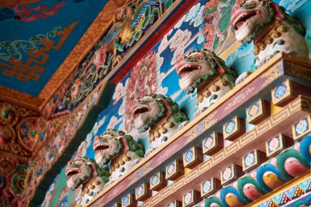 Leones de nieve con melenas de color turquesa bajorrelieves en la pared sobre la entrada al templo budista, decoración decorativa y religiosa de la antigua fachada del templo, leones de nieve mitológica animal celeste del Tíbet