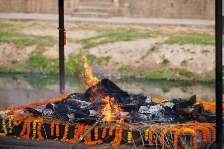 Pira funeraria ardiente para la ceremonia de cremación en el complejo del templo de Pashupatinath, Nepal, práctica antigua de despedir a difuntos que simboliza la naturaleza cíclica de la vida y la muerte