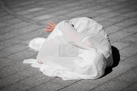 Foto de Artista femenina cubierta de bufanda de seda blanca ondeando con gracia, actuación de danza al aire libre femenina en baldosas de la calle creando sensual y conmovedor espectáculo al aire libre - Imagen libre de derechos